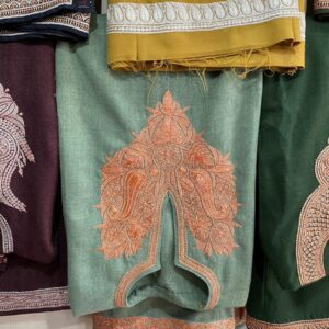 a bunch of different colored pants hanging on a wall