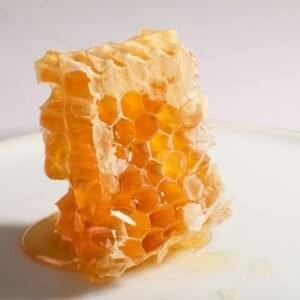 A piece of honeycomb with dripping honey